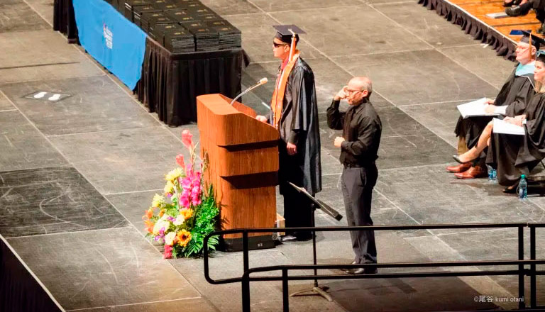 Qusay speaking at graduation